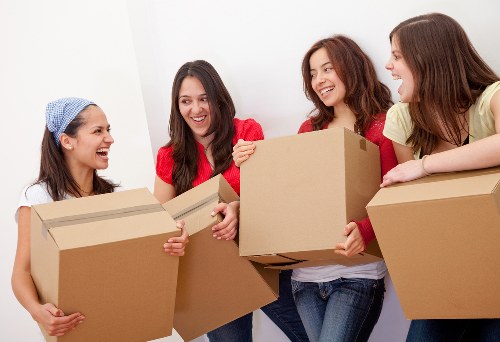 Professional movers carrying a sofa through a central London property