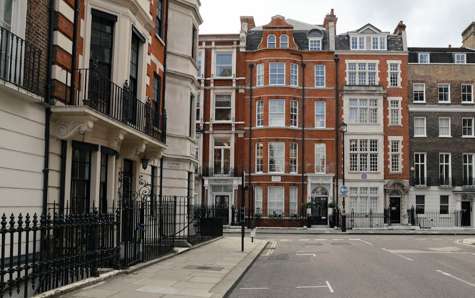 The image shows a historic multi-storey building with ornate stone architecture and large arched windows on the ground floor, located on a busy city street. The building features the word 'HARRORDS' d
